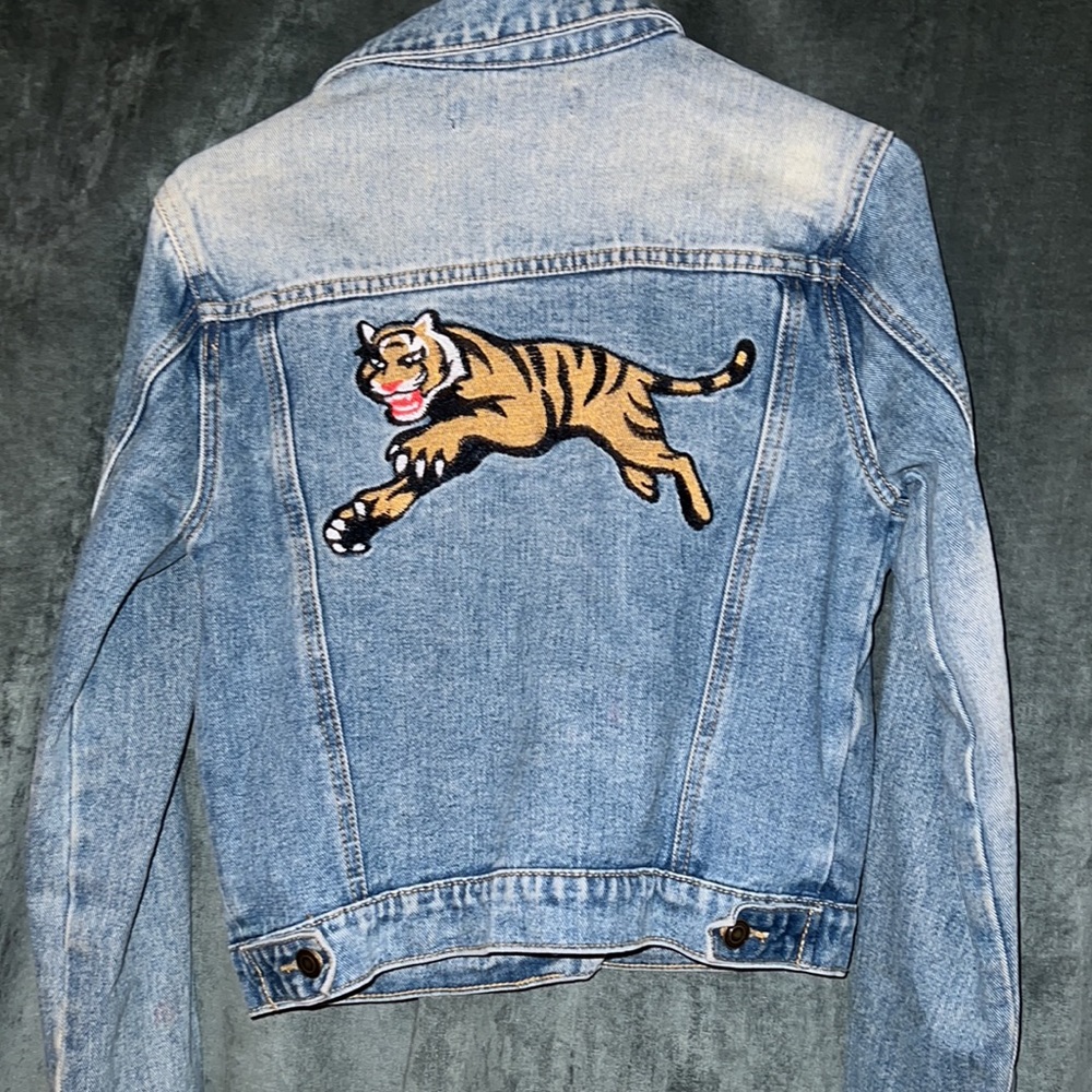 Jean jacket with tiger embroidered patch on the back.